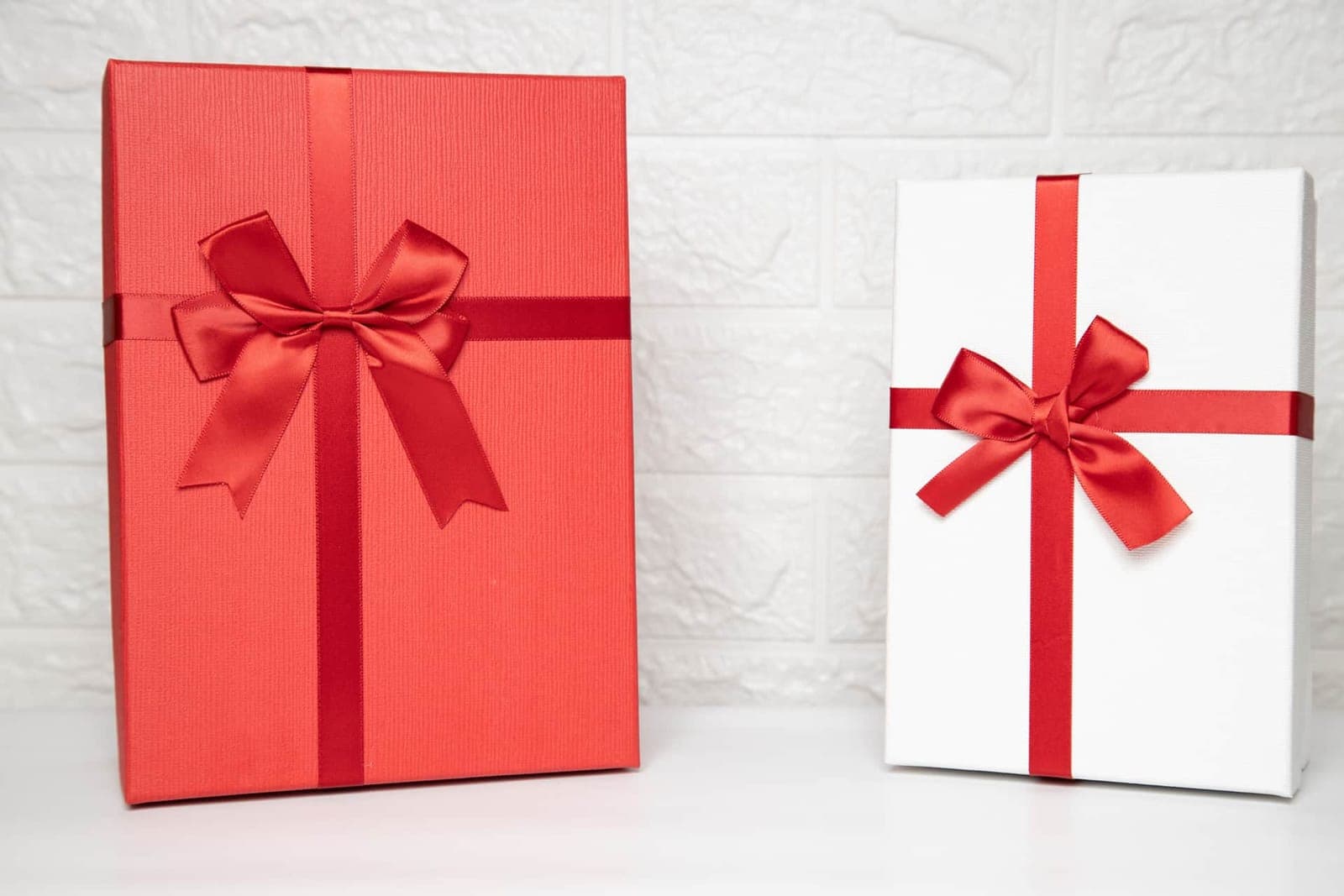 Two gift boxes tied with red ribbon