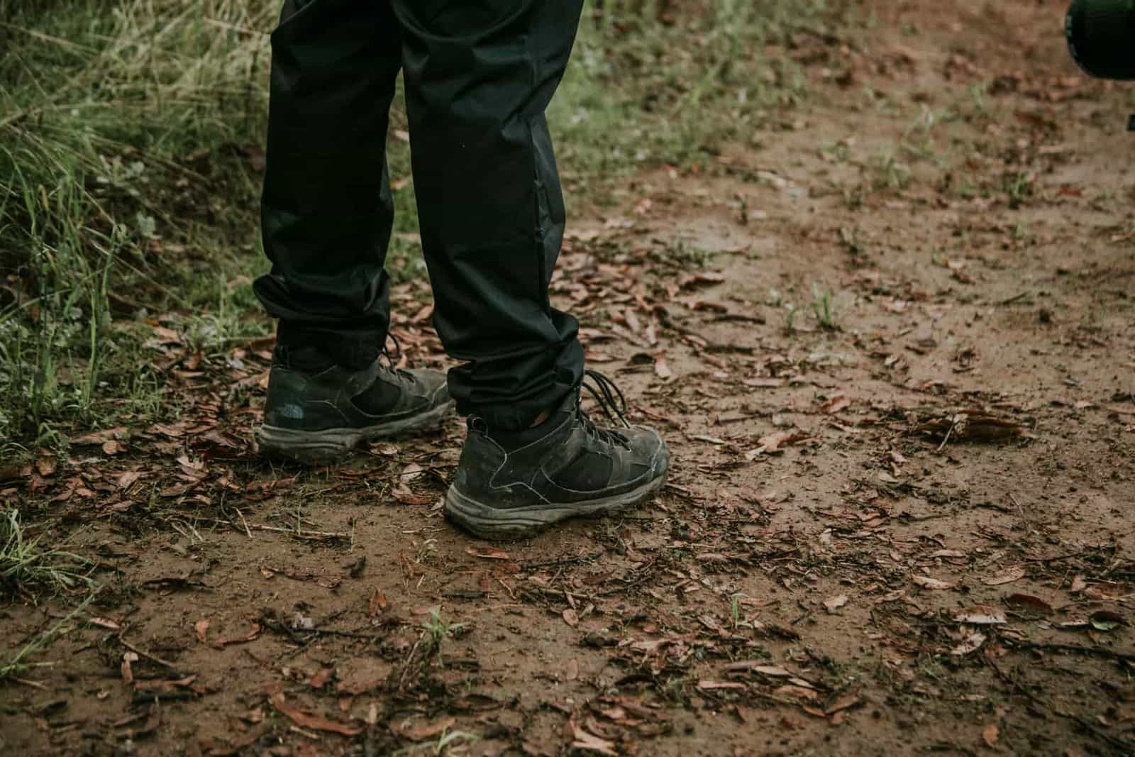 Legs and shoes on a muddy forest path
