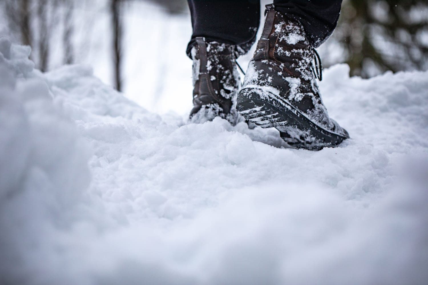 Hiking boots stepping through fresh snow