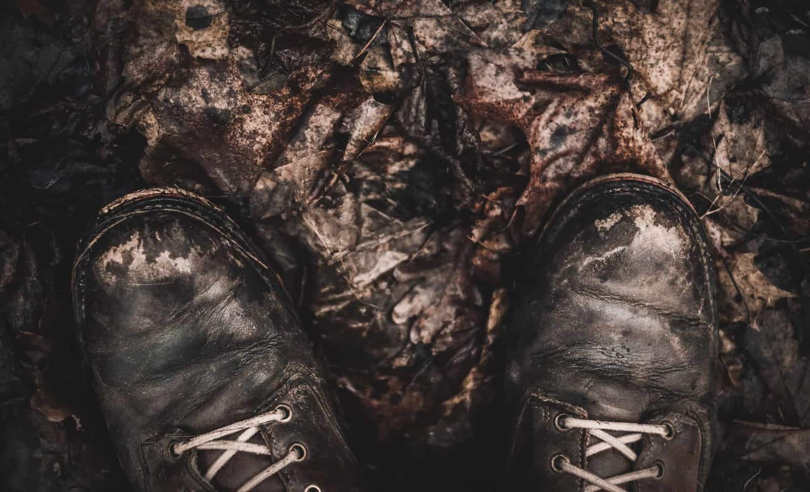 Muddy leather boots seen from above