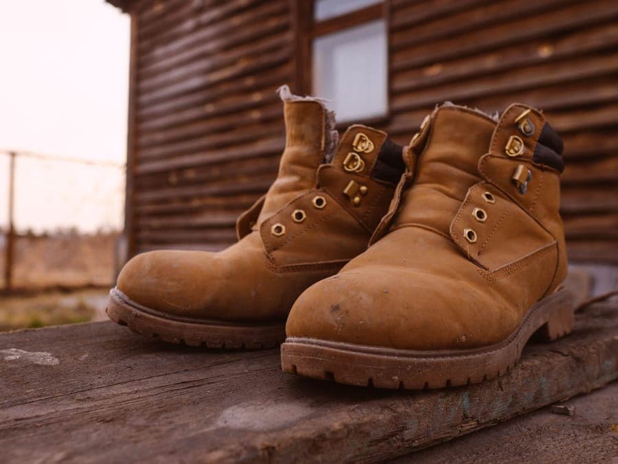 A pair of rugged suede boots on a wooden cabin deck