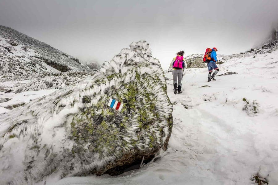 Hikers on a snowy mountain trail