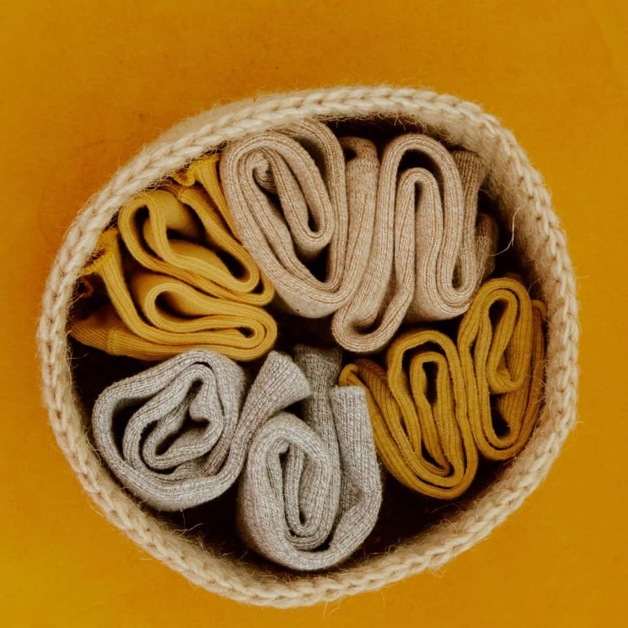 Rolled socks arranged in a woven basket